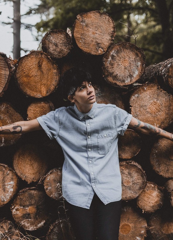 Stylish young man posing near wood logs Stock Photo