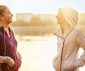 Two girls using smartphones listening to music Stock Photo 02