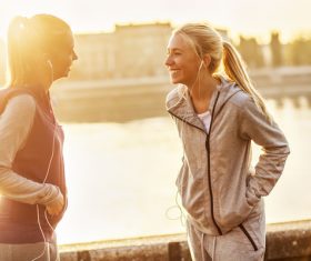 Two girls using smartphones listening to music Stock Photo 04