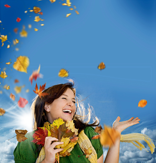 Woman collecting autumn leaves happy Stock Photo