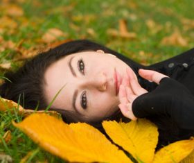 Woman lying on dead leaves Stock Photo