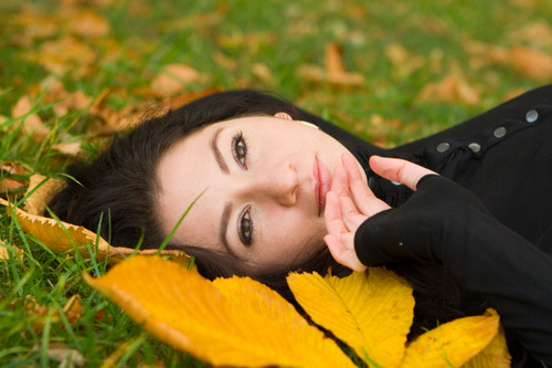Woman lying on dead leaves Stock Photo