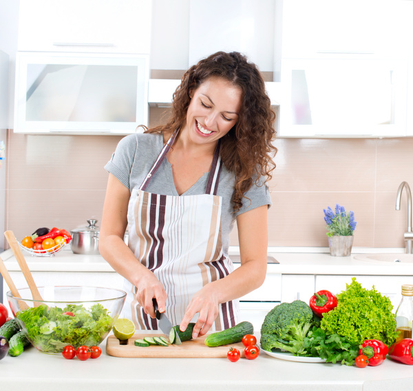 Woman making salad in the kitchen Stock Photo