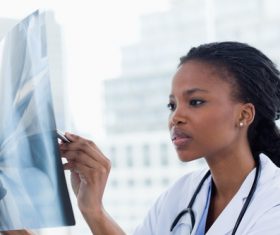 Young female doctor viewing X-ray film Stock Photo