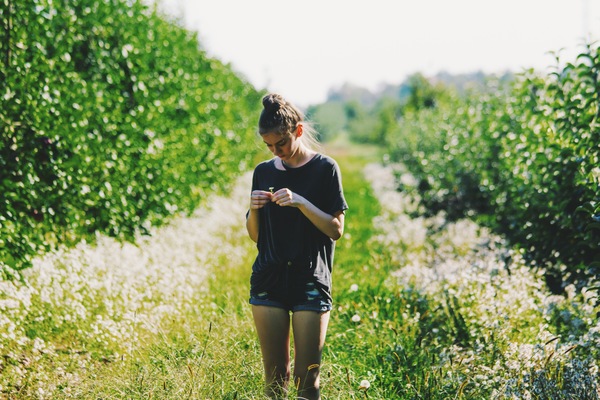 Young girl standing in the orchard Stock Photo