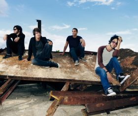 Young man sitting on scrap iron rack Stock Photo