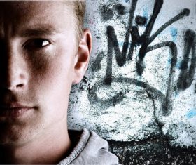 Young man with graffiti on the wall Stock Photo