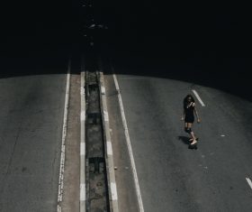 Young woman playing roller skate on road Stock Photo