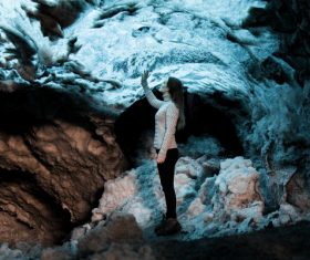 Young woman posing in frozen stone cave Stock Photo