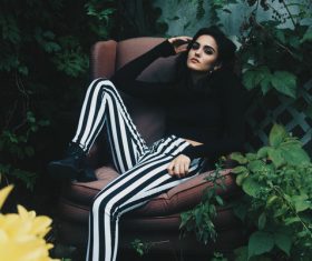 attractive woman posing on sofa in garden Stock Photo