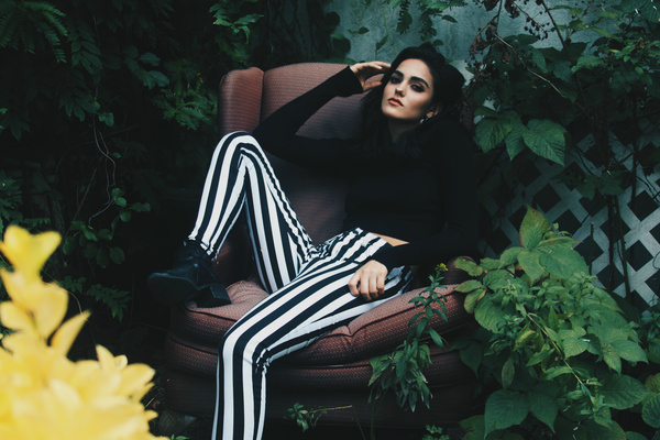 attractive woman posing on sofa in garden Stock Photo