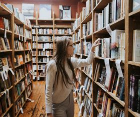 girl looking for books in library Stock Photo