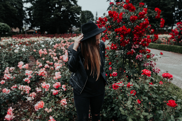 woman posing on beautiful blooming roses garden Stock Photo