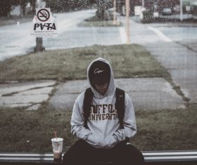 young boy sitting under cold weather Stock Photo