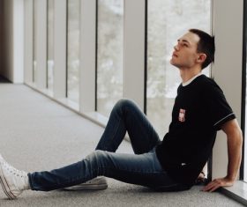 young man sitting on ground Stock Photo