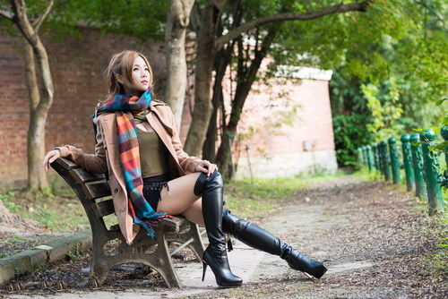 Asian girl posing on bench outdoors Stock Photo