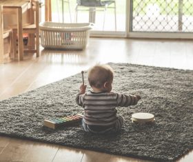 Baby playing alone on the carpet Stock Photo