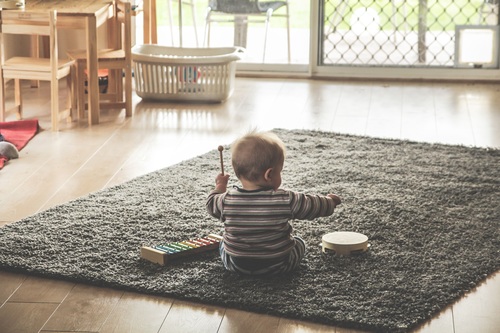 Baby playing alone on the carpet Stock Photo