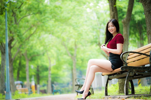 Beautiful Asian girl sitting on bench Stock Photo