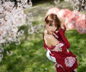 Beautiful Japanese girl under cherry blossom tree Stock Photo