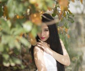 Beautiful asian girl posing under the plant Stock Photo
