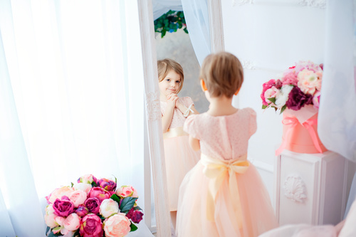 Beautiful little girl dressed in front of the mirror Stock Photo 02