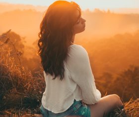 Beautiful young woman posing at sunset scene Stock Photo