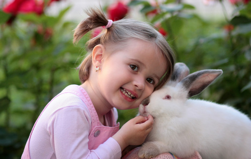 Big eyes little girl playing with bunny Stock Photo