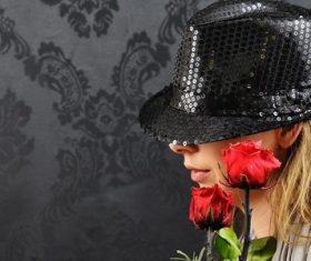 Blonde woman posing with black hat and roses Stock Photo