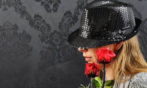 Blonde woman posing with black hat and roses Stock Photo