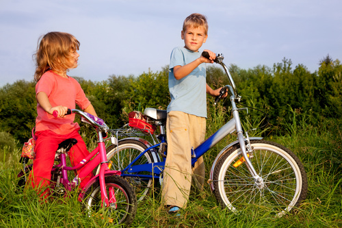 Brother and sister riding bicycle Stock Photo