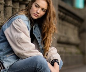 Casual style dressed woman sitting on the street Stock Photo