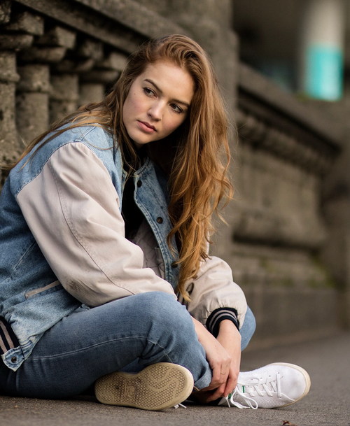 Casual style dressed woman sitting on the street Stock Photo