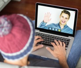 Chat online with friends using laptop Stock Photo