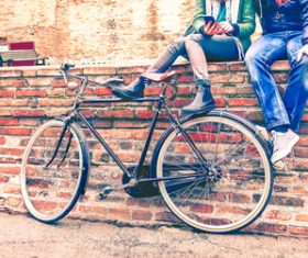 Couple sitting on the wall and playing with smartphone Stock Photo