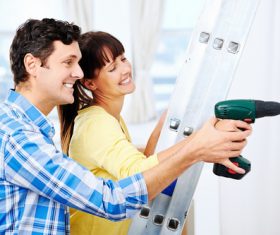 Couples with punch holes in the wall Stock Photo