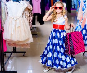Cute little girl holding shopping bags posing in mall Stock Photo