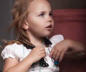 Cute little girl wearing a necklace Stock Photo
