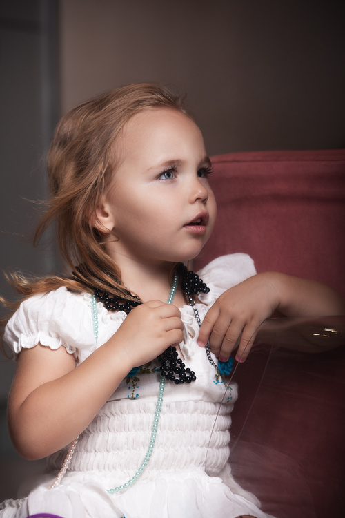 Cute little girl wearing a necklace Stock Photo