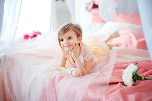 Dressed up beautiful little girl sitting on the bed Stock Photo 03