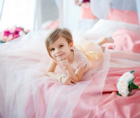 Dressed up beautiful little girl sitting on the bed Stock Photo 04