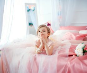 Dressed up beautiful little girl sitting on the bed Stock Photo 07