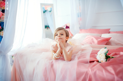 Dressed up beautiful little girl sitting on the bed Stock Photo 07
