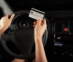 Driving woman holding bank card in hand Stock Photo