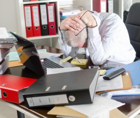 Exhausted man with excessive work pressure Stock Photo