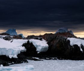 Frozen ice on rocky beach in winter Stock Photo