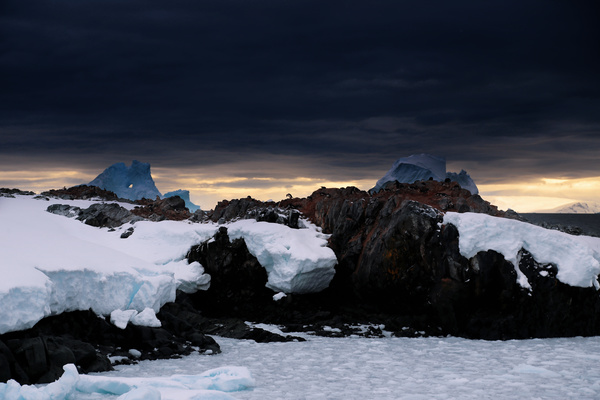 Frozen ice on rocky beach in winter Stock Photo