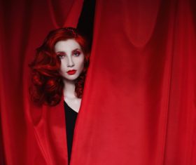 Girl hiding in red drapery Stock Photo