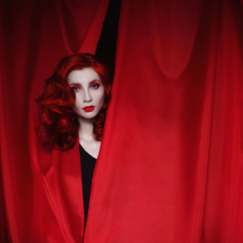 Girl hiding in red drapery Stock Photo