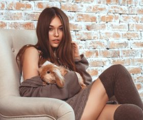 Girl holding pet sitting on the sofa Stock Photo